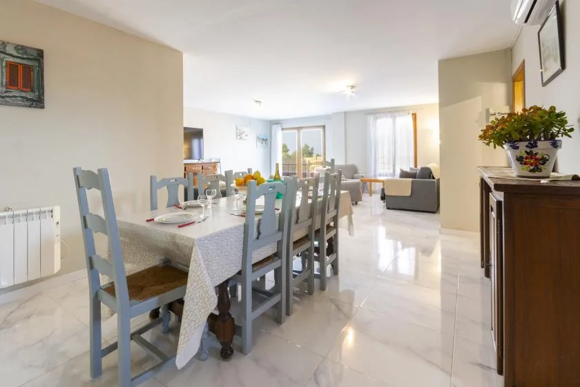 A bright dining area opens into a living space, with a table and seating.