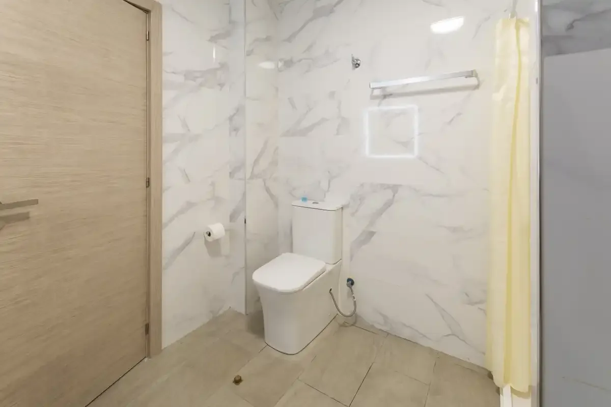 A bathroom with a toilet and a shower curtain.