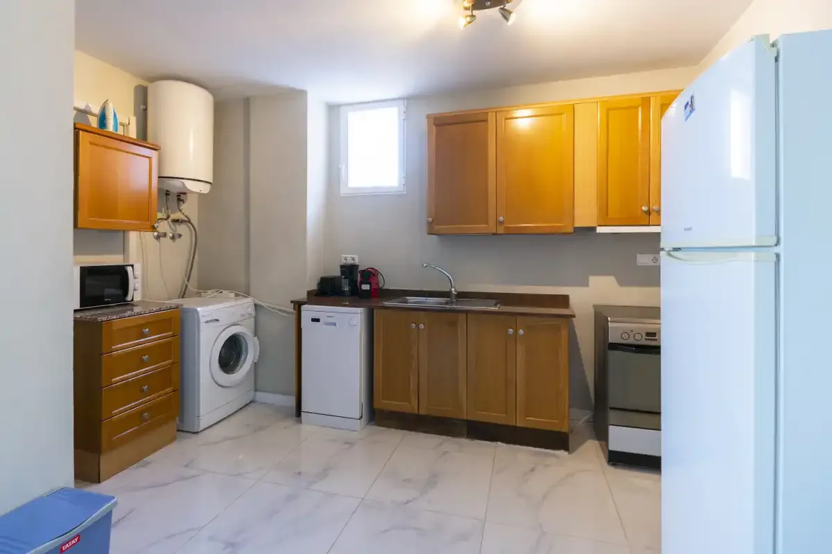 A kitchen with wooden cabinets, a sink, and white appliances.