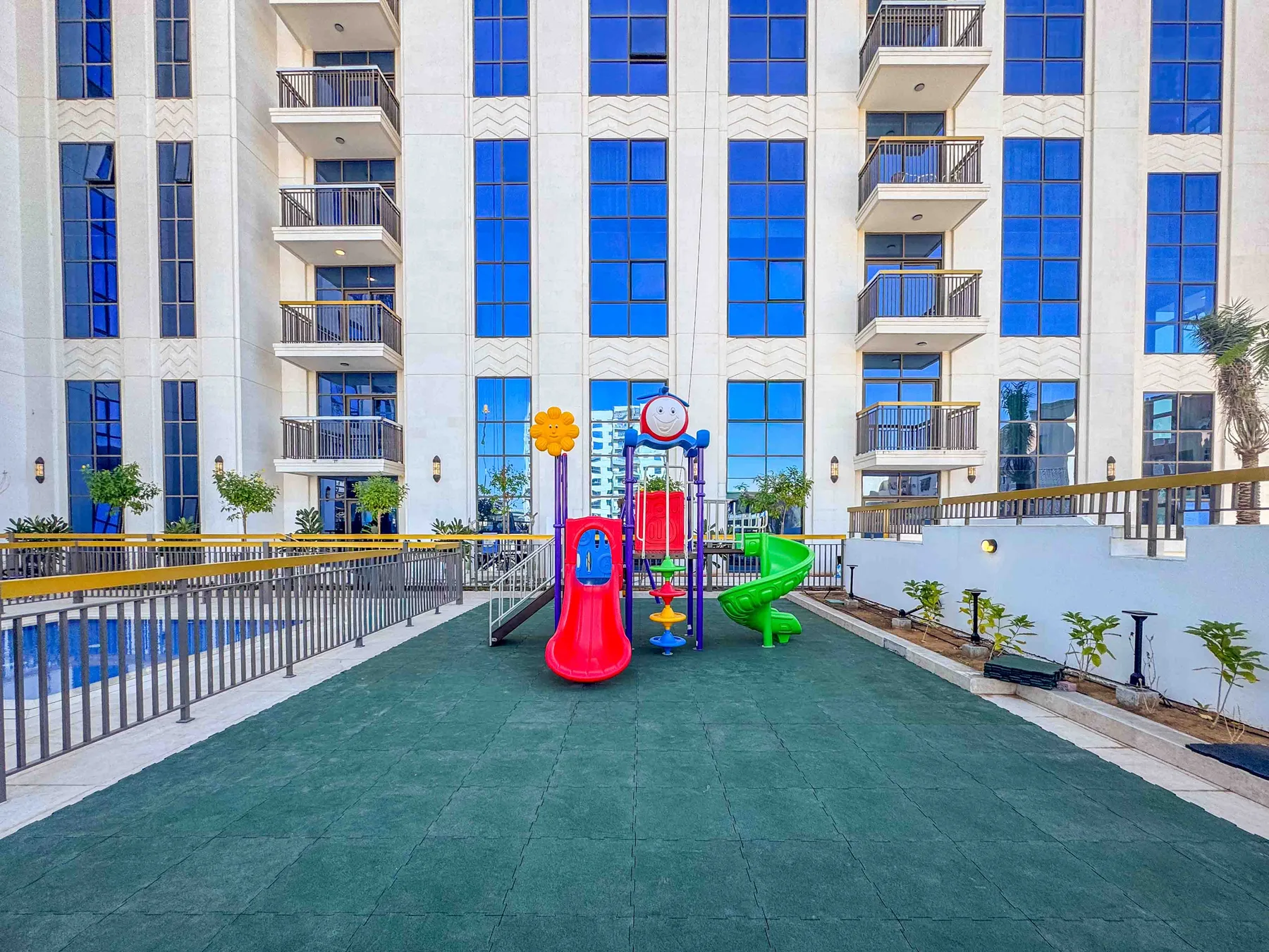 Un parque infantil con toboganes de colores está frente a un edificio alto.
