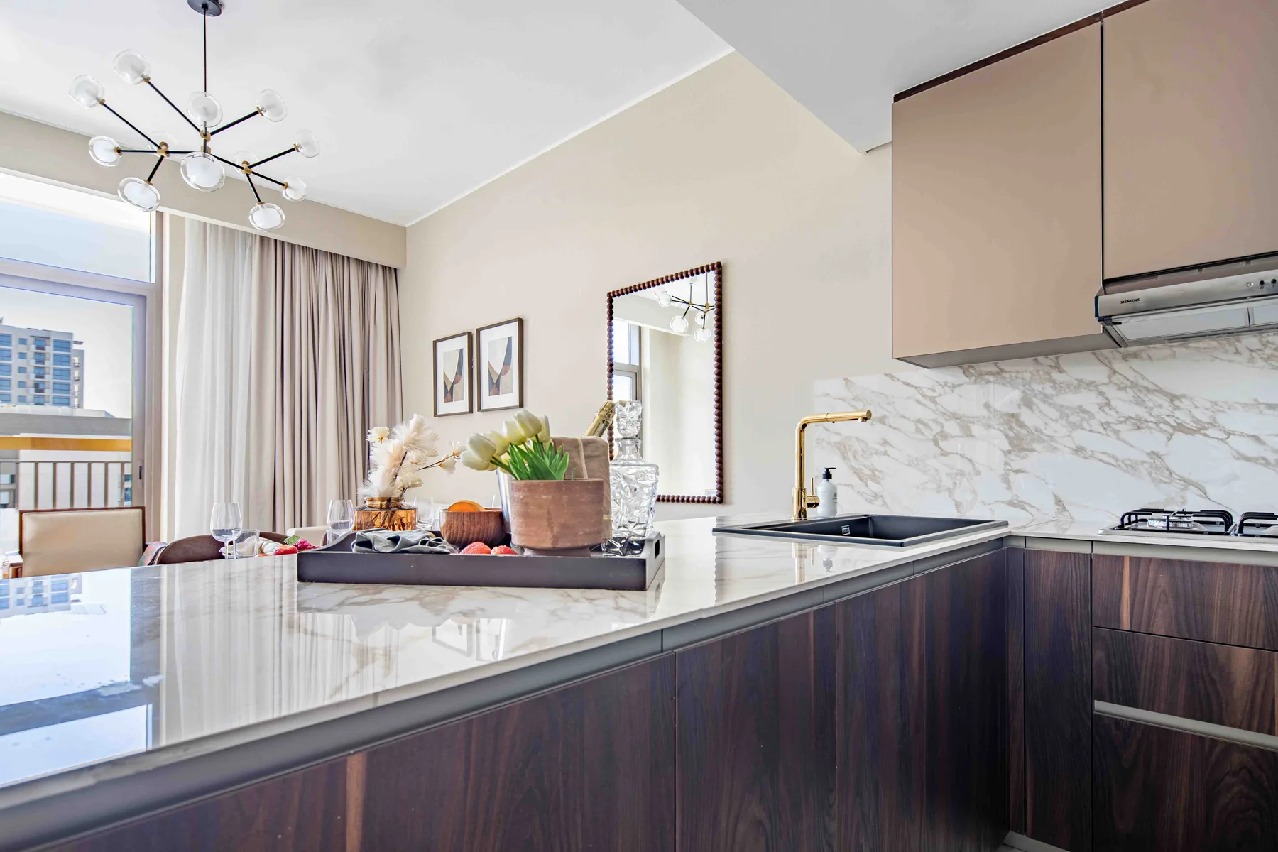 Una cocina luminosa con una isla grande y un comedor junto a la ventana.