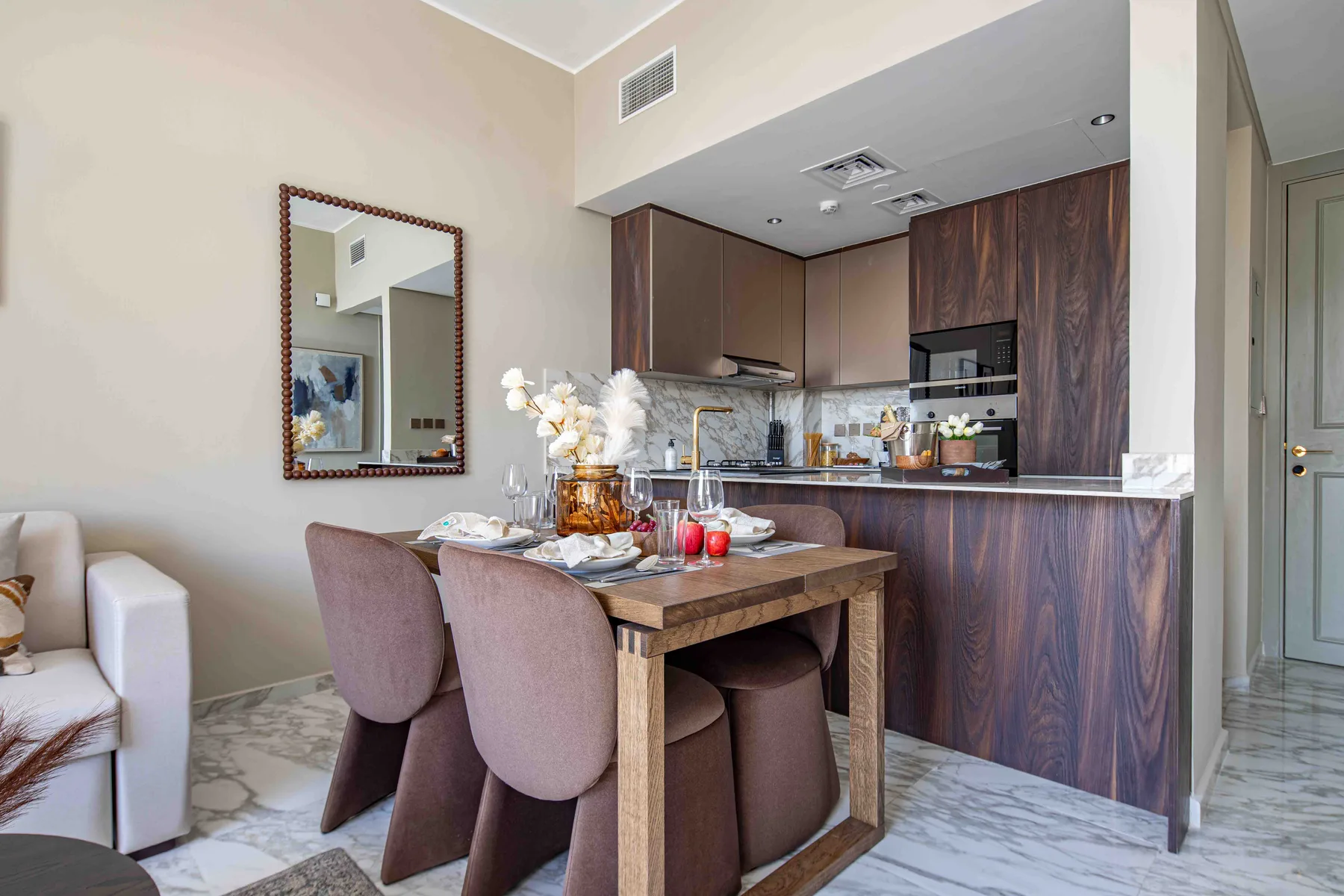 Un comedor con la mesa puesta junto a una cocina compacta.