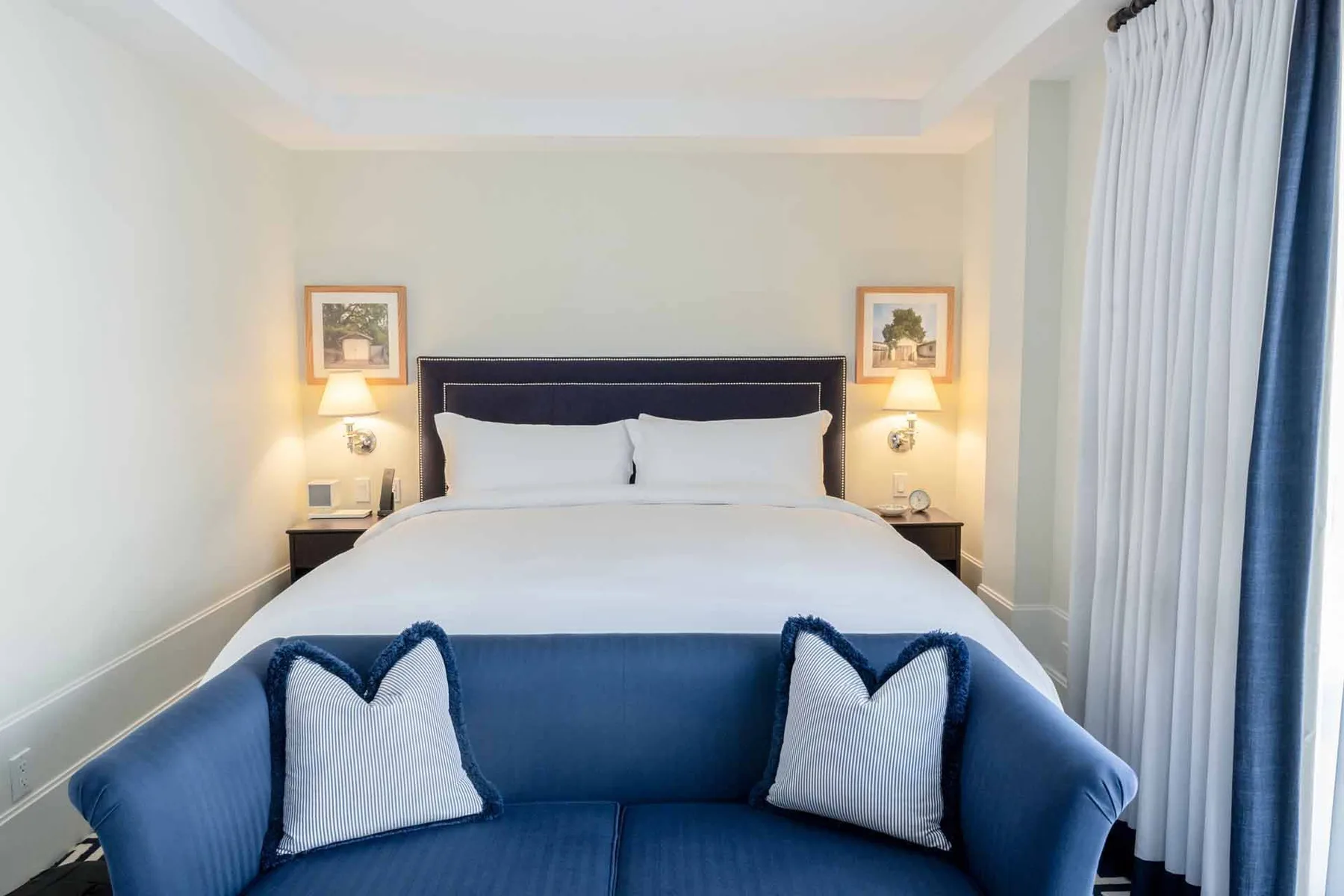 Habitación con cama, sofá y obras de arte en la pared
