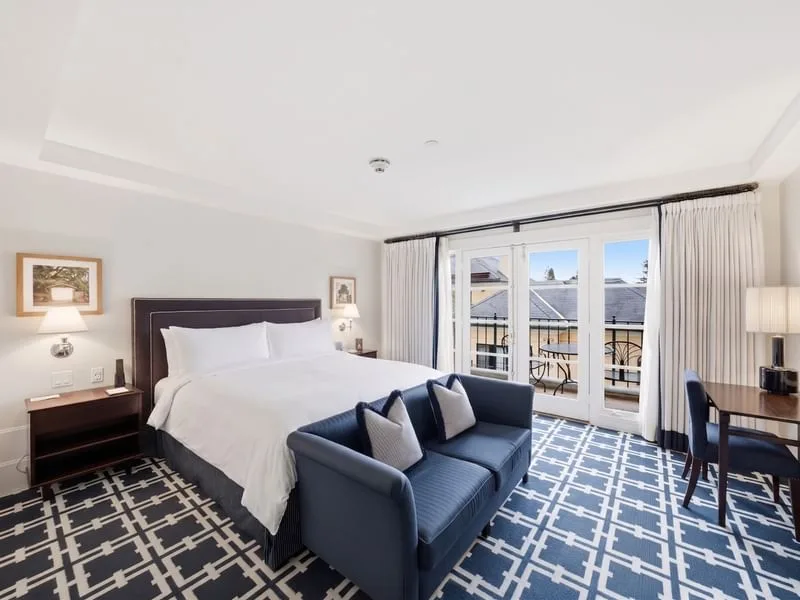 Habitación Deluxe con cama king, sofá y puertas al balcón
