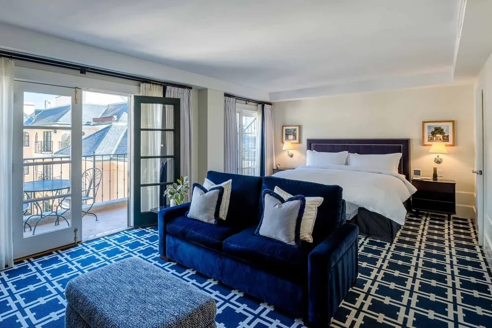 Habitación del hotel con cama, sofá y balcón