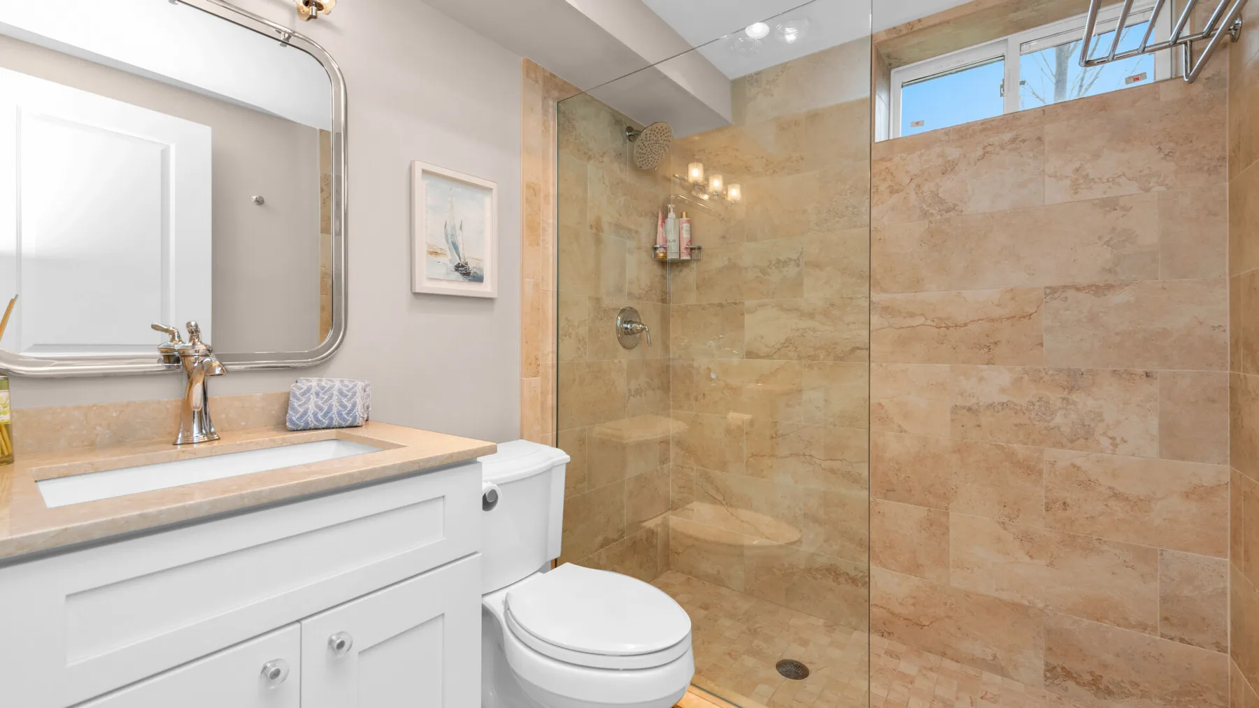 A bathroom with a vanity, toilet, and glass-enclosed shower.
