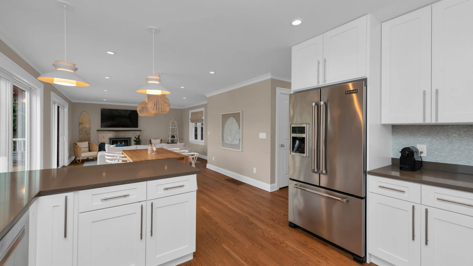 A bright kitchen with white cabinetry, a central island, and stainless steel appliances.