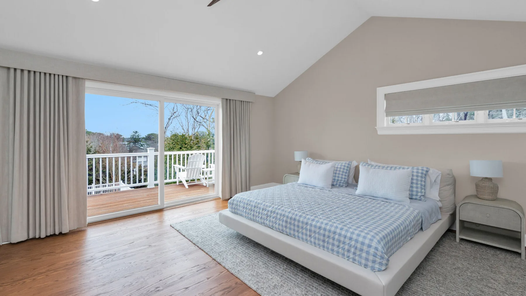 A bedroom with a large bed beside sliding glass doors and a balcony.