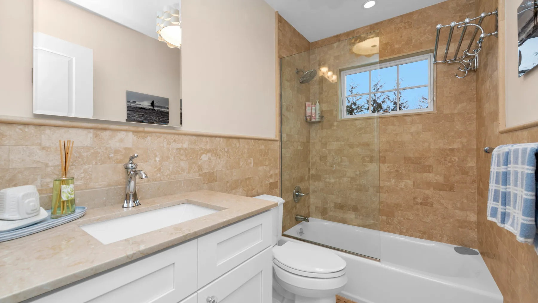 A bathroom with a vanity, toilet, and bathtub with shower.