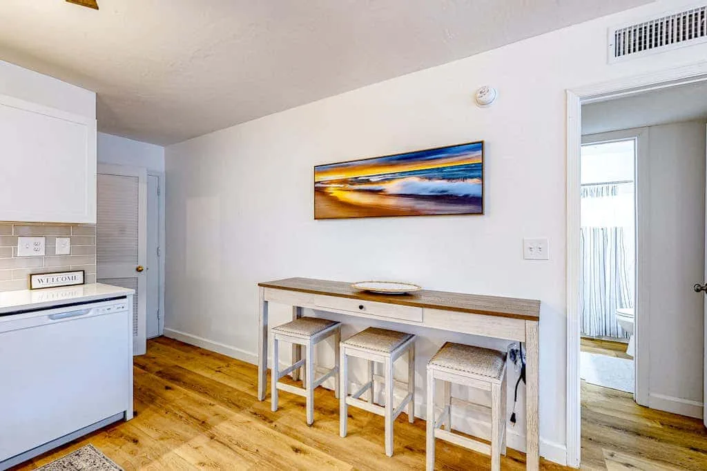 A bright kitchen and dining area with a counter and stools.