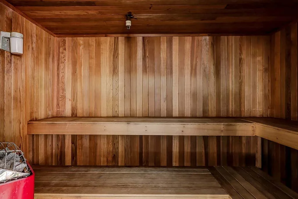 A wood-paneled sauna with tiered wooden seating.