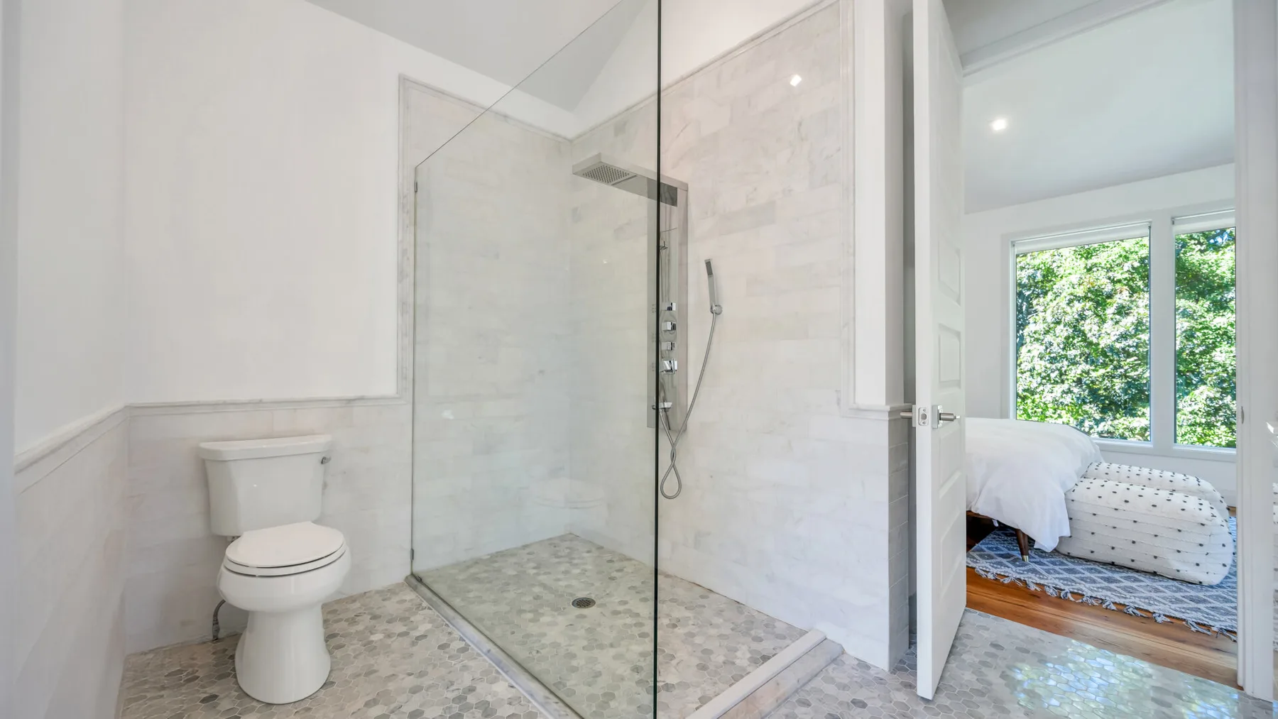 A bathroom with a glass-enclosed shower and a toilet.