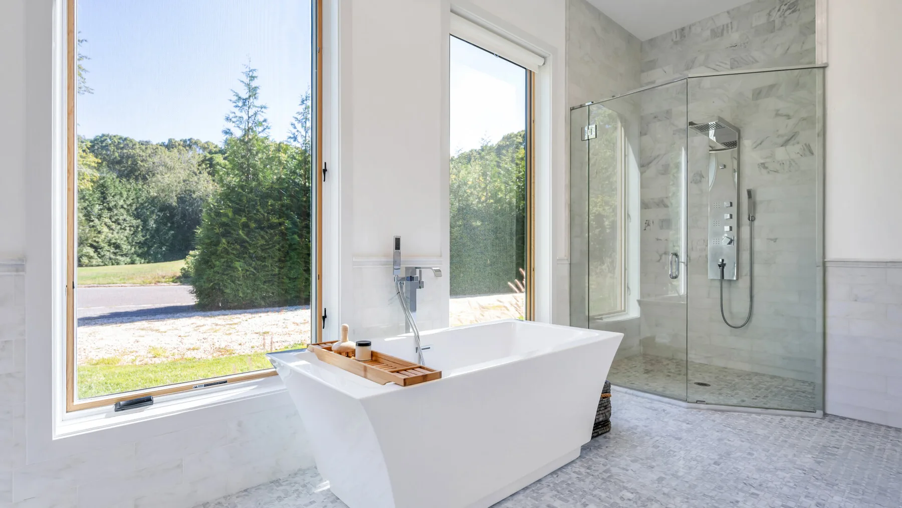 A bright bathroom with a freestanding tub beside a walk-in shower.