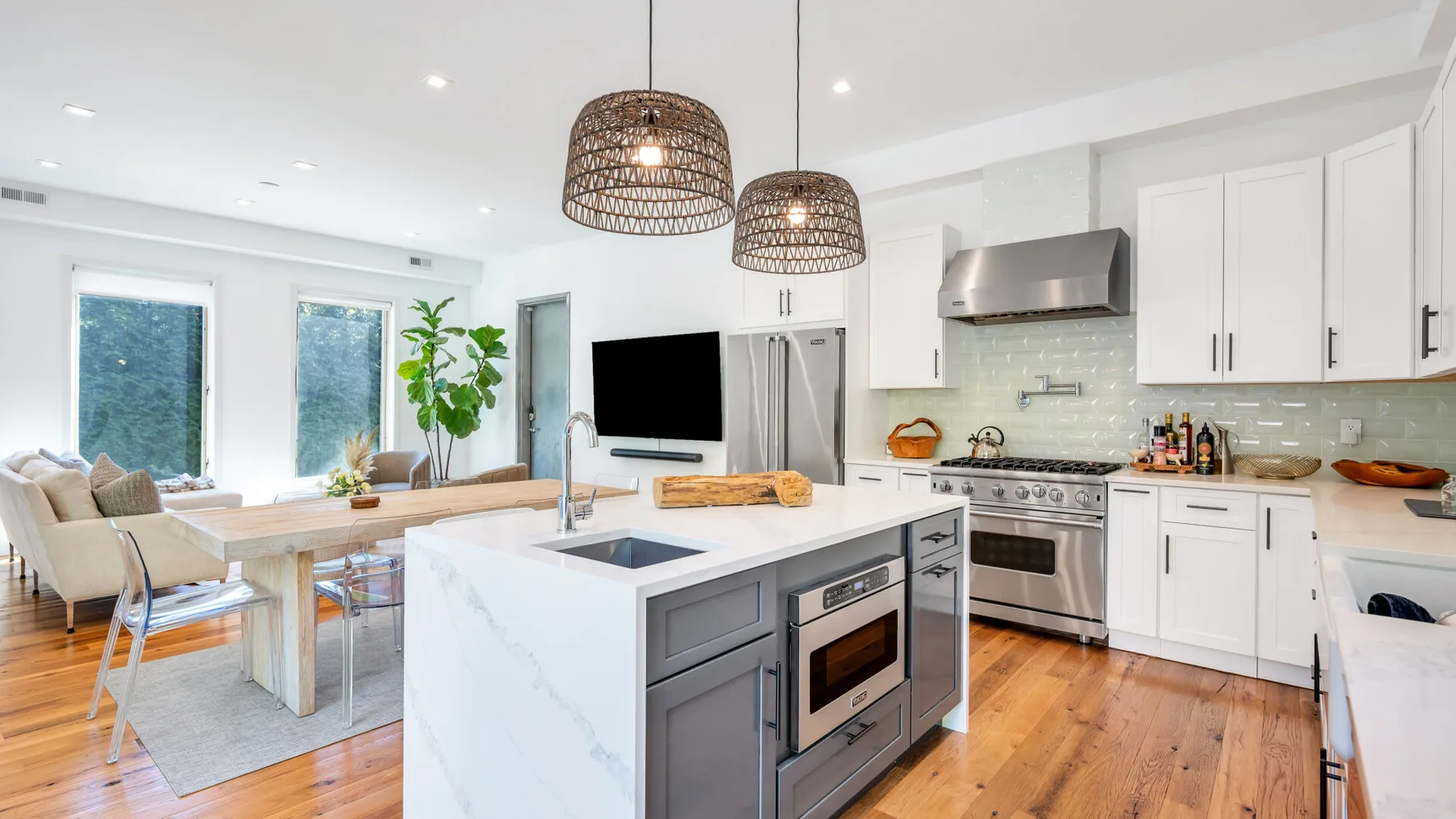 A bright open-plan kitchen and dining area with a central island and dining table.