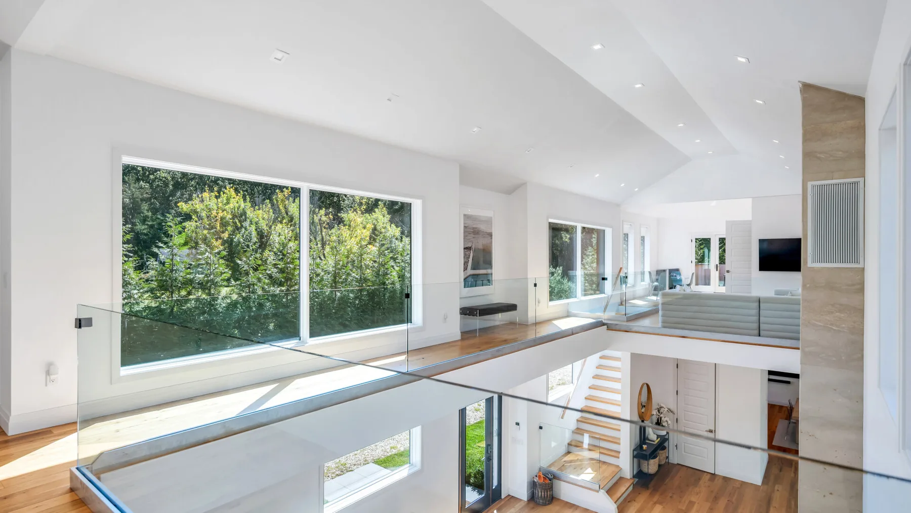 A bright modern interior with large windows overlooking leafy greenery.