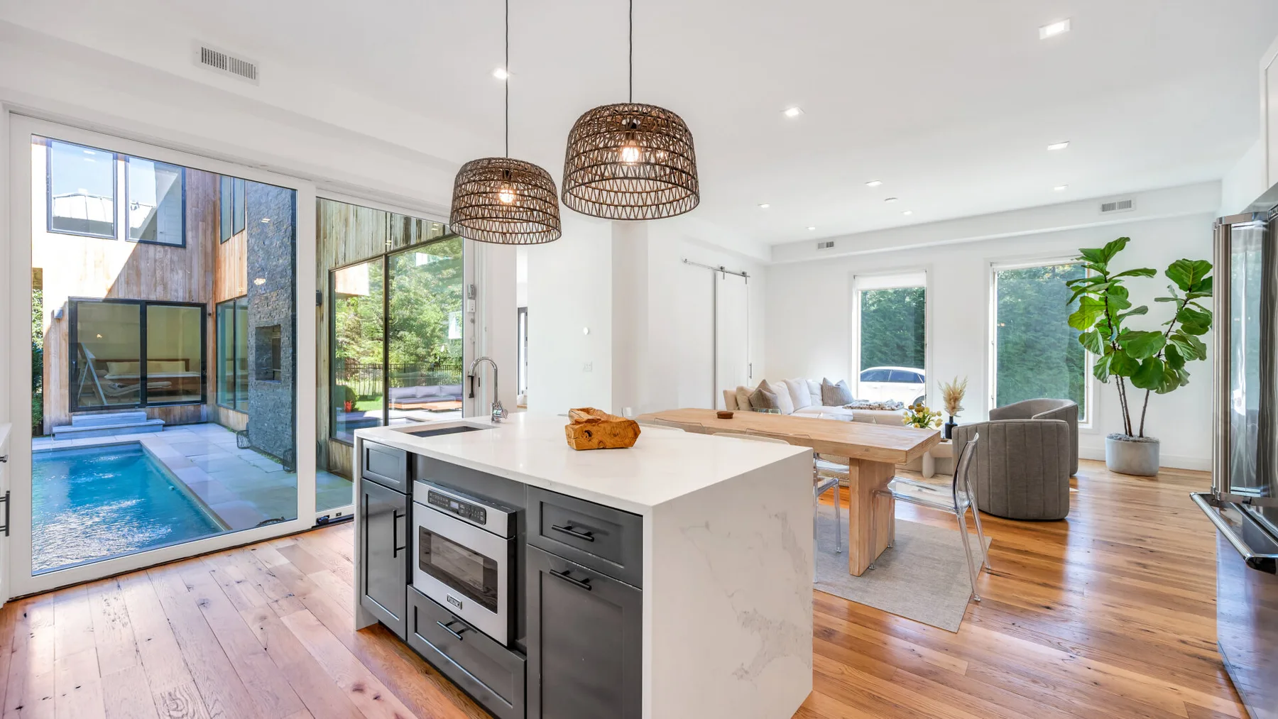 A bright open-plan kitchen and dining area with an island and large windows.