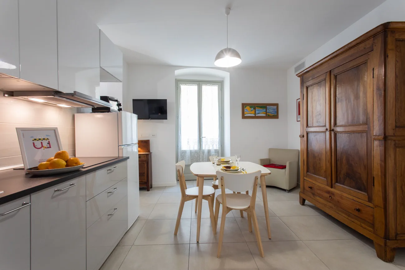 Una cocina y comedor luminosos con una mesa junto a una ventana grande.