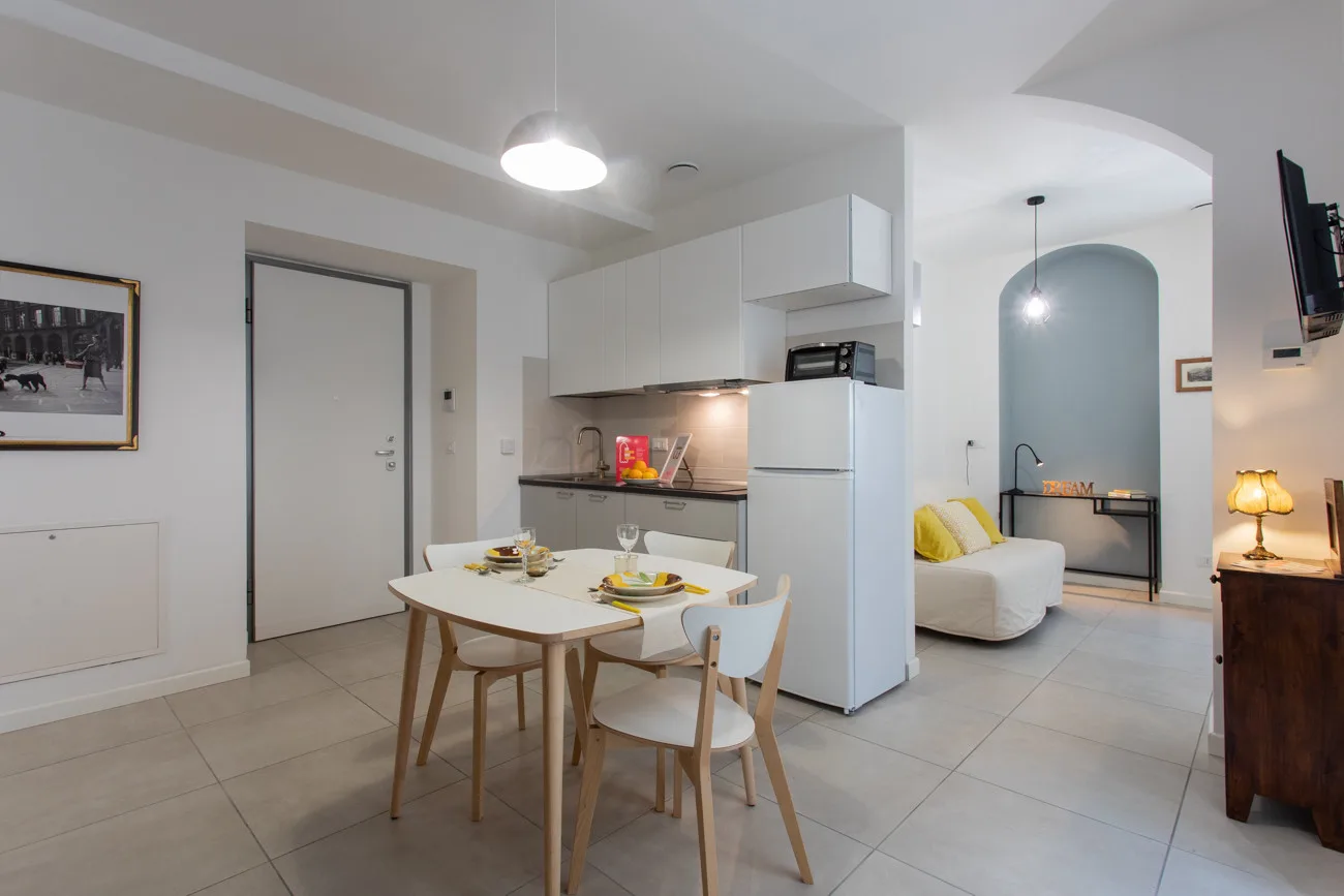 Una habitación luminosa y diáfana combina una cocina pequeña, una mesa de comedor y una zona de estar.