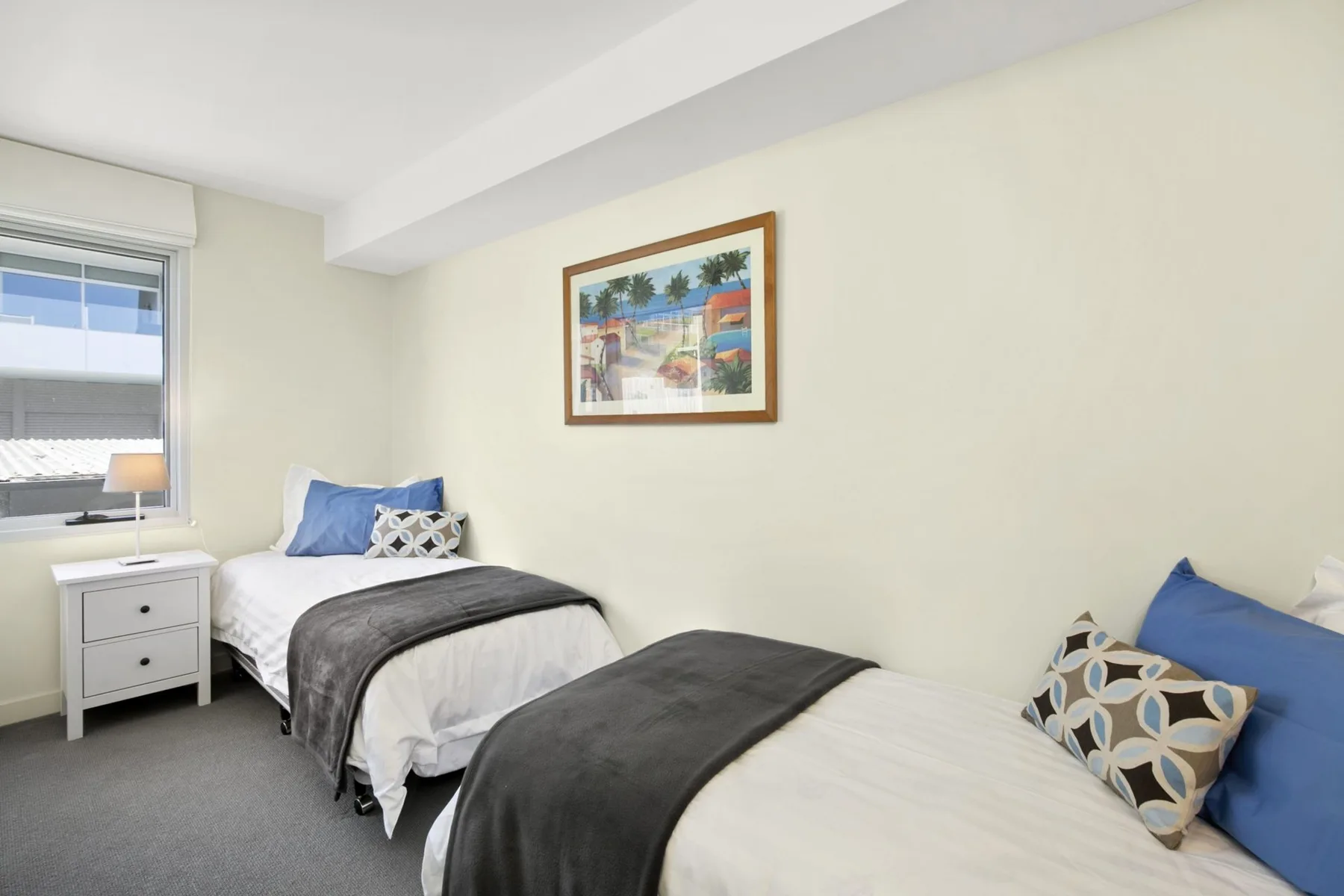 Un dormitorio con dos camas y un cuadro enmarcado en la pared.