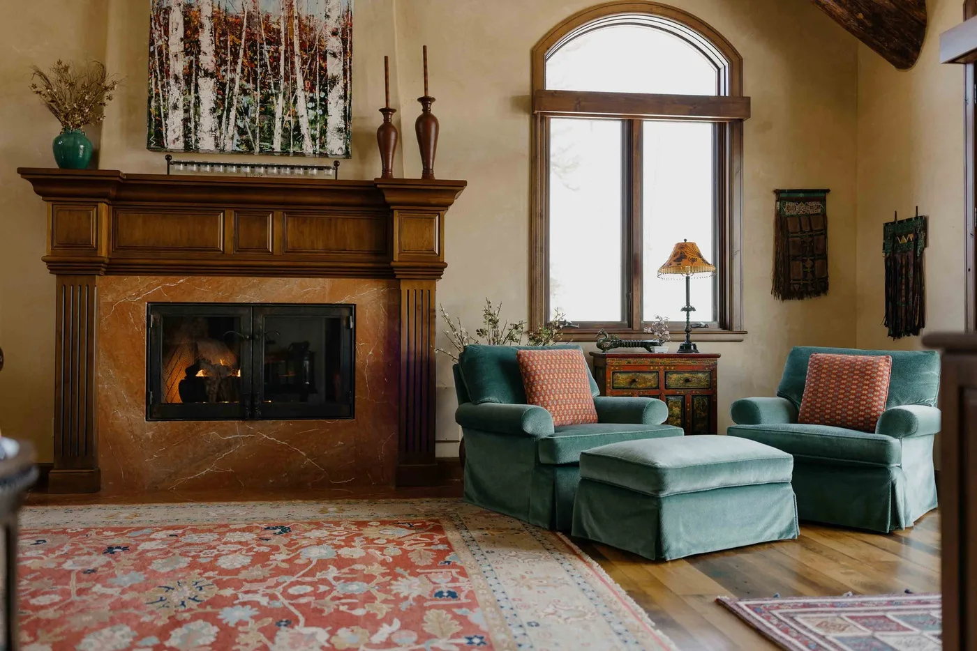 A living room with upholstered seating, a fireplace, and a large window.