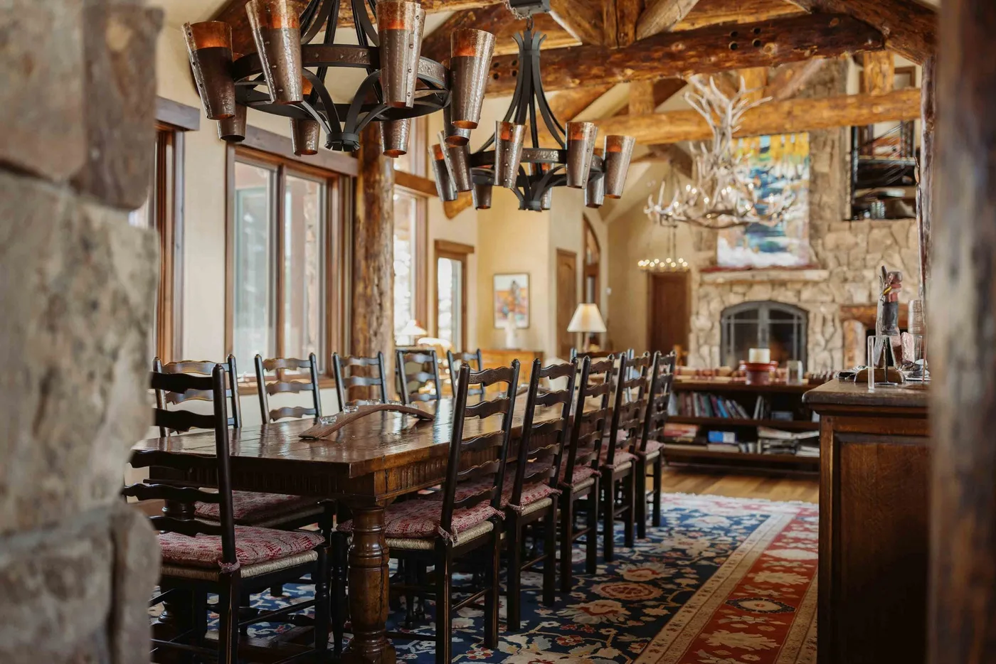 A rustic dining room with a long wooden table and rows of chairs.