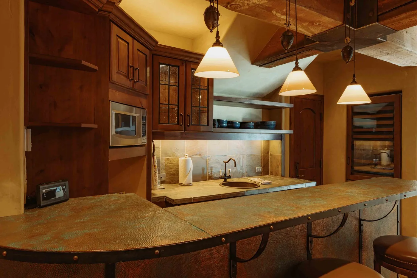 A kitchen with wooden cabinets and a broad counter in the foreground.