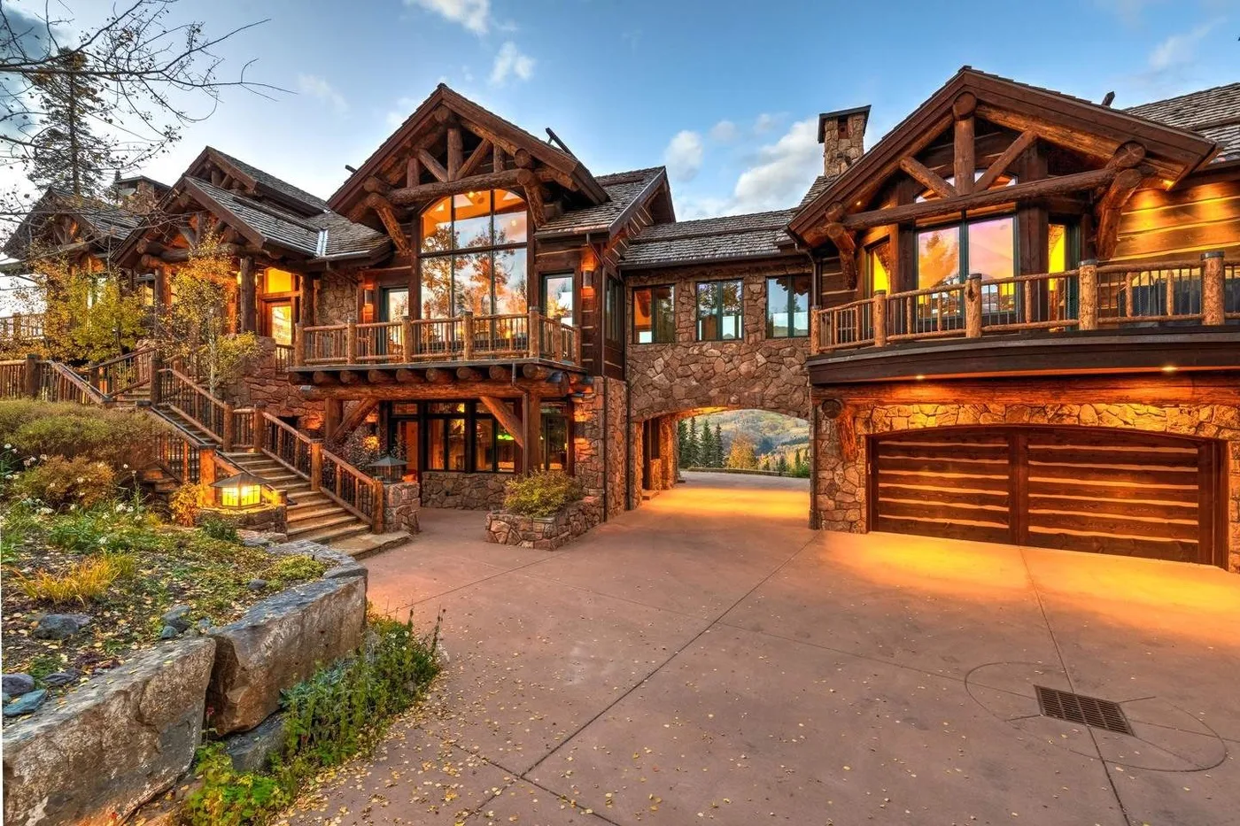 A large timber lodge exterior with balconies, a stone entryway, and a wide paved driveway.