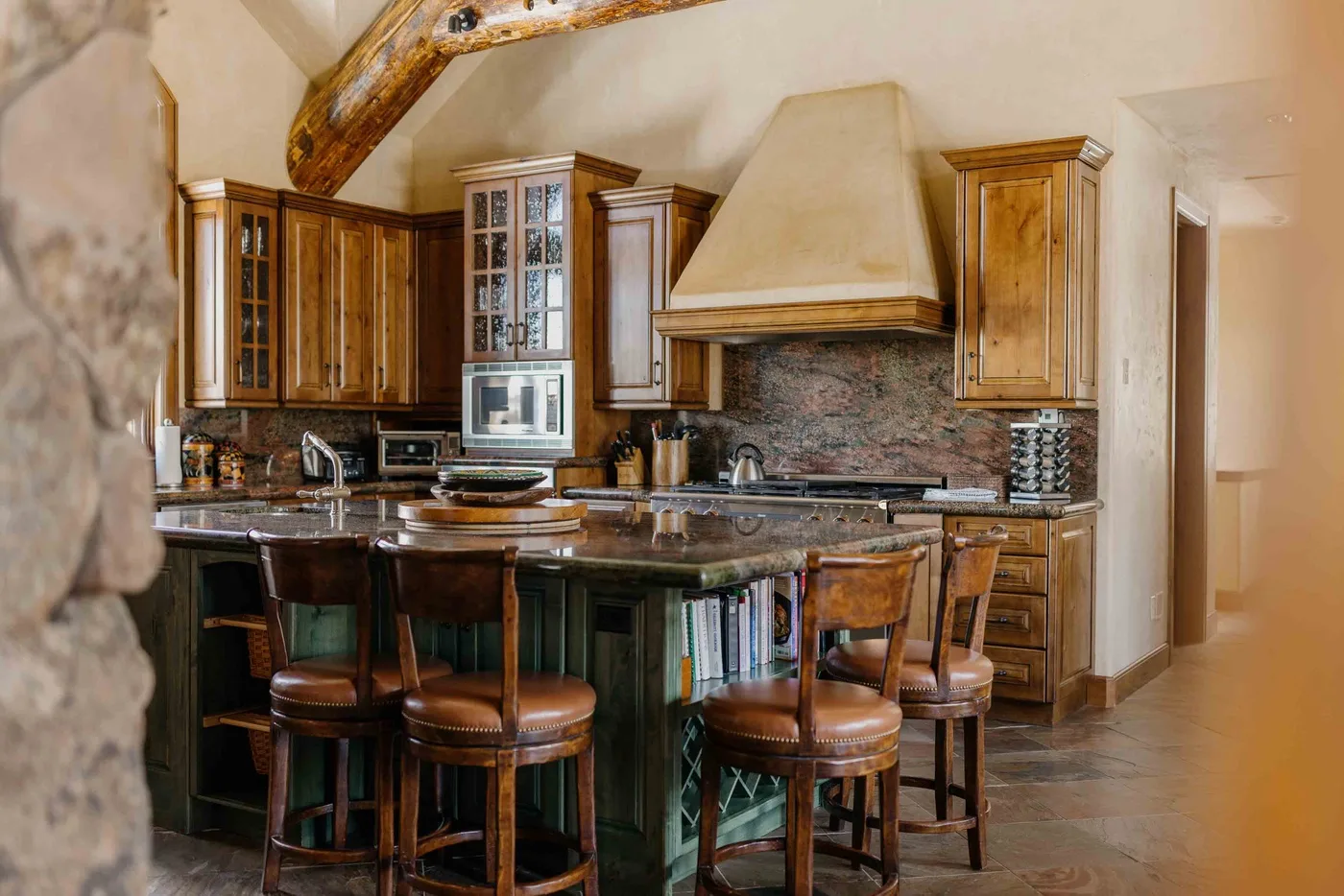 A kitchen with wooden cabinetry, a cooking range, and bar seating.