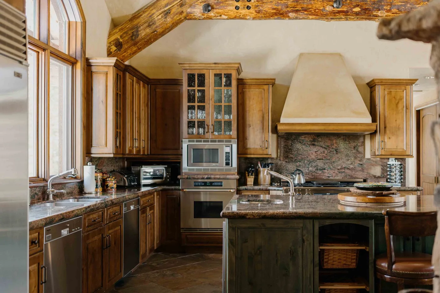 A spacious kitchen with wooden cabinets, a central island, and a large range hood.