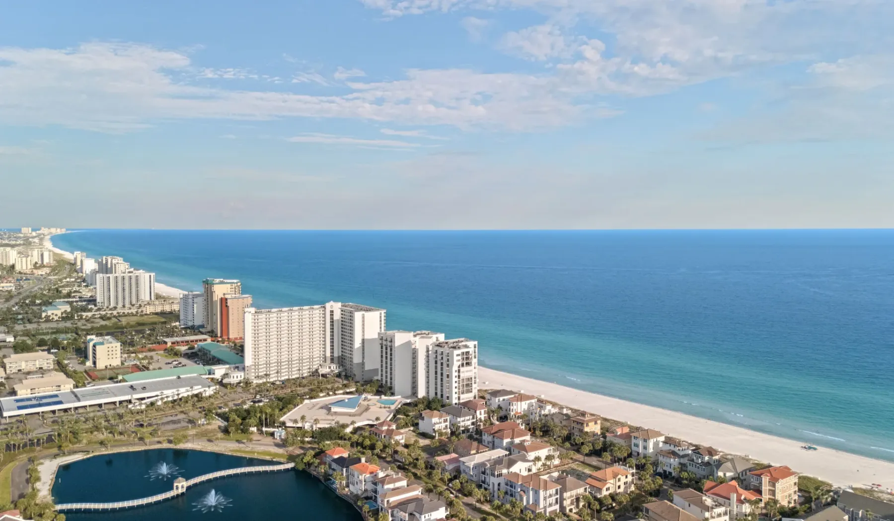 Horizonte urbano costero junto a una extensa playa de arena y el océano.