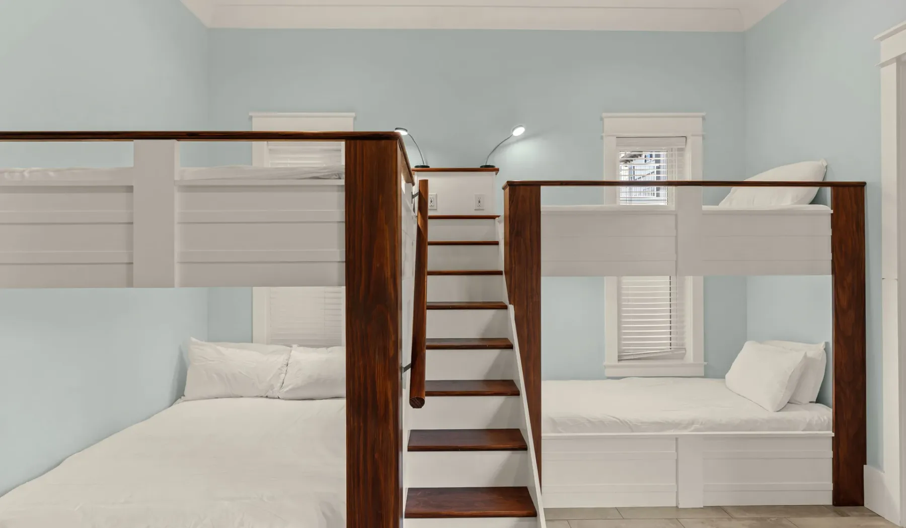 Un dormitorio con dos zonas elevadas para dormir conectadas por una escalera.