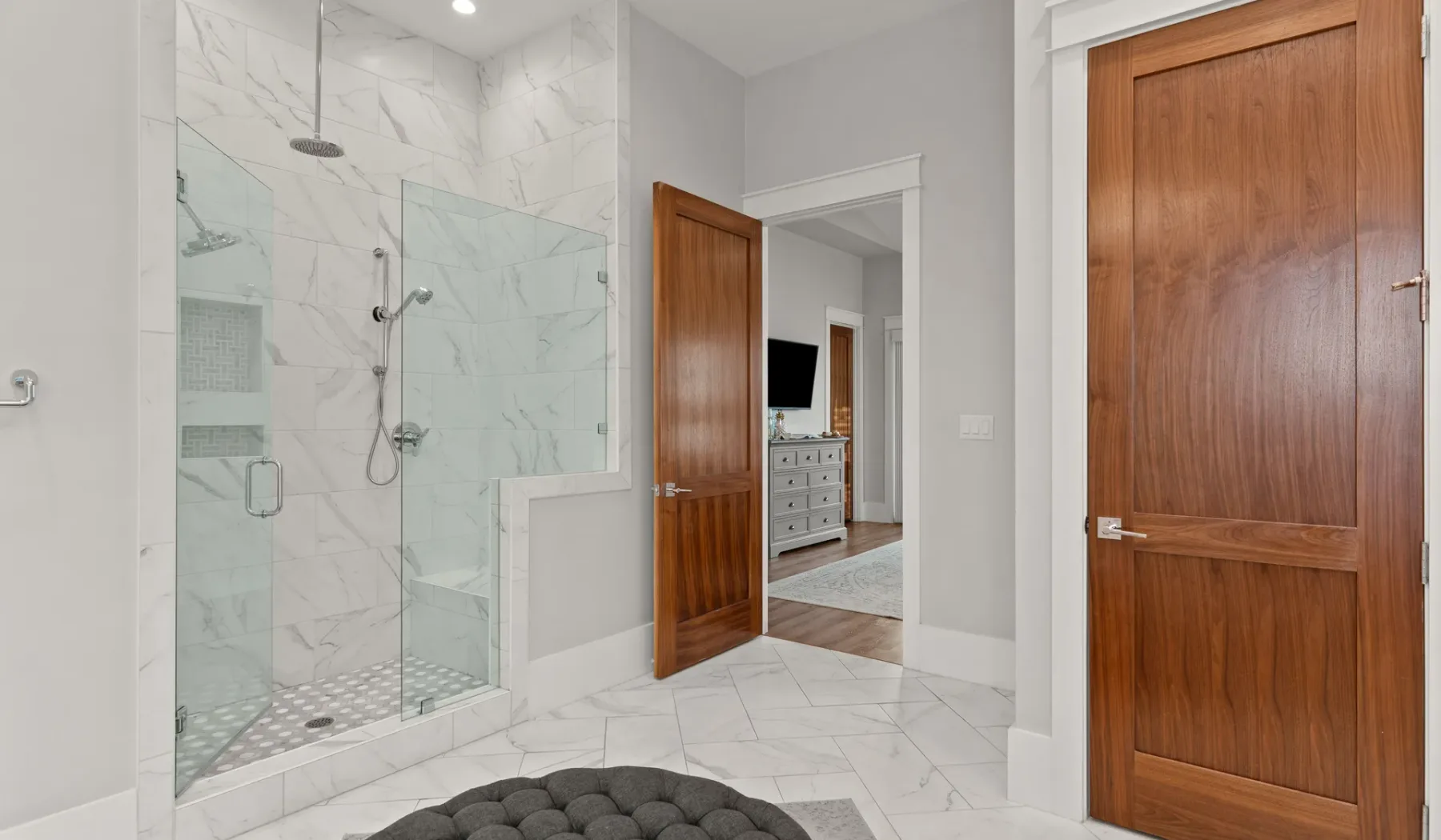 Un baño con ducha de vidrio y puertas de madera.