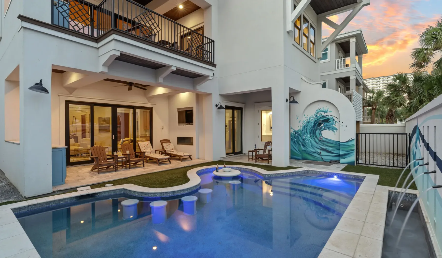 Una piscina en el patio junto a un edificio de varias plantas con un mural de olas.