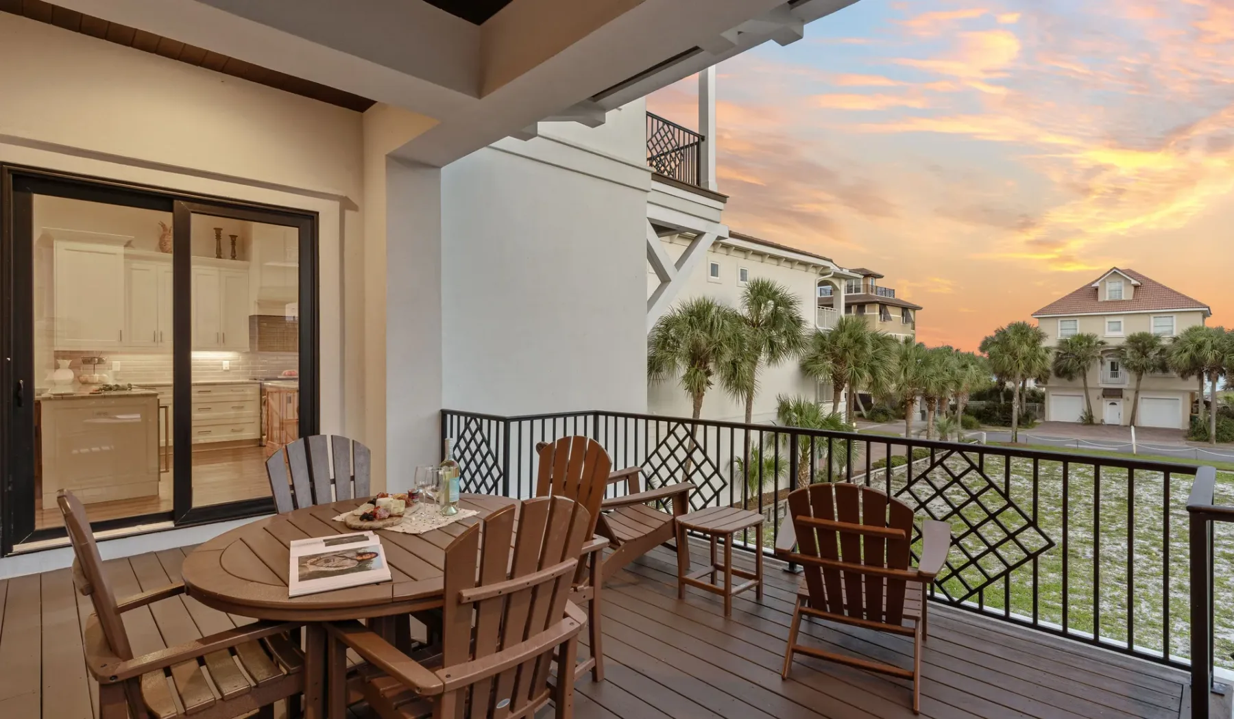 Una terraza exterior cubierta con asientos da a casas vecinas al atardecer.