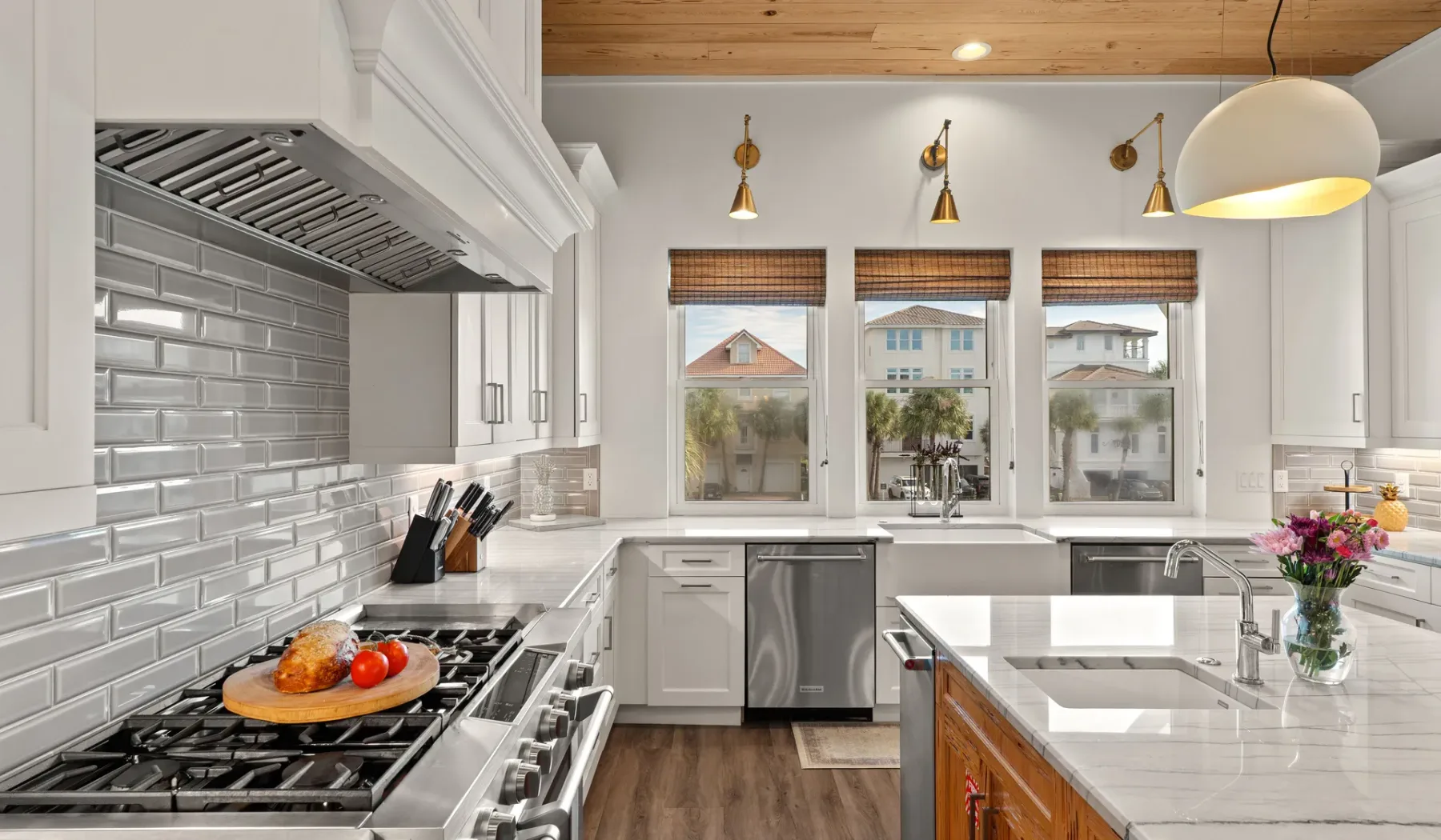 Una cocina luminosa con gabinetes blancos, un salpicadero de azulejos y una isla grande.