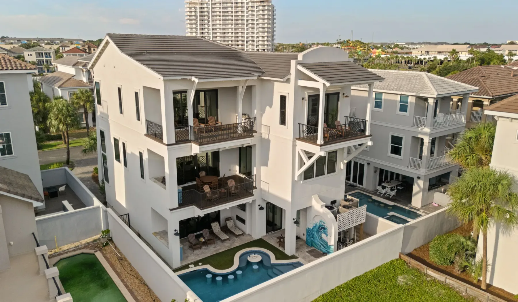 Vista aérea de casas modernas alrededor de una piscina y jardines.