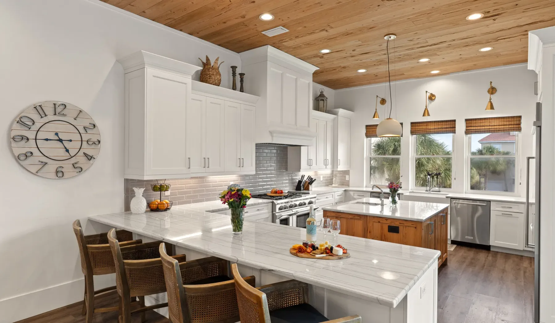 Una cocina luminosa con gabinetes blancos, una isla central y una barra de comedor.