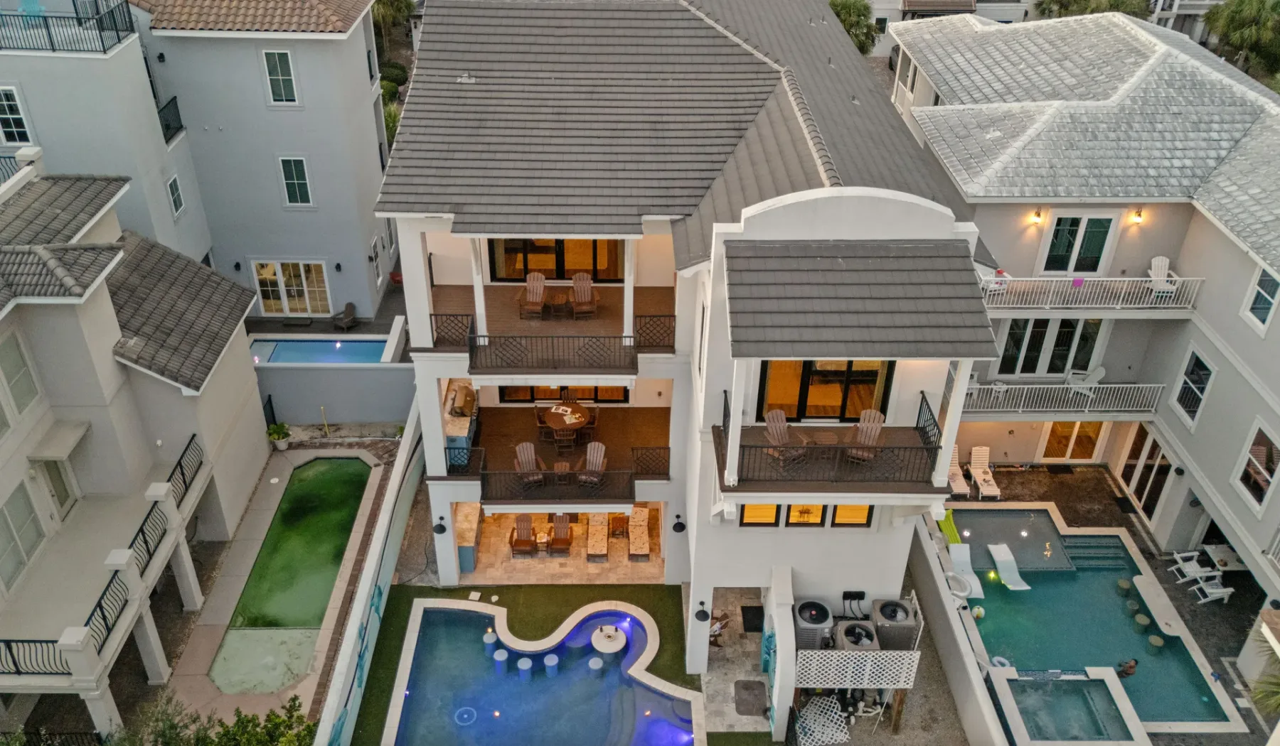 Vista aérea de casas contiguas con balcones y piscinas.