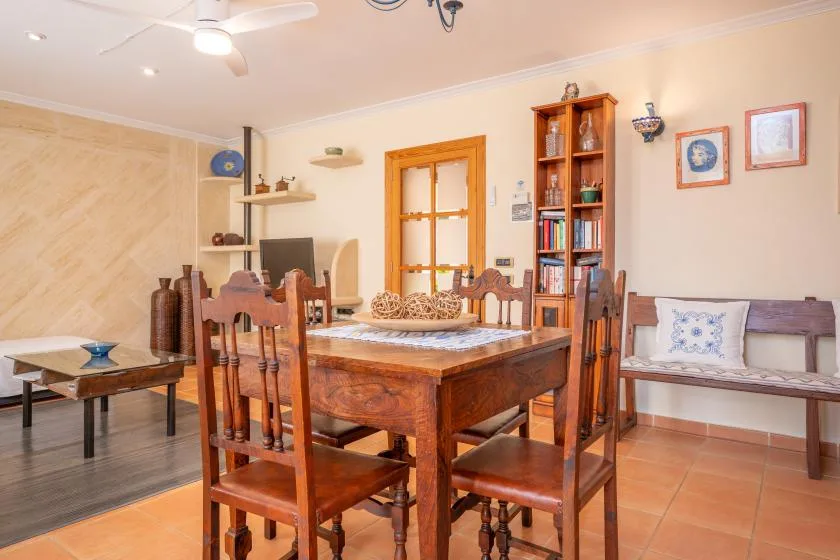 A dining room with a wooden table and chairs beside a built-in bench.