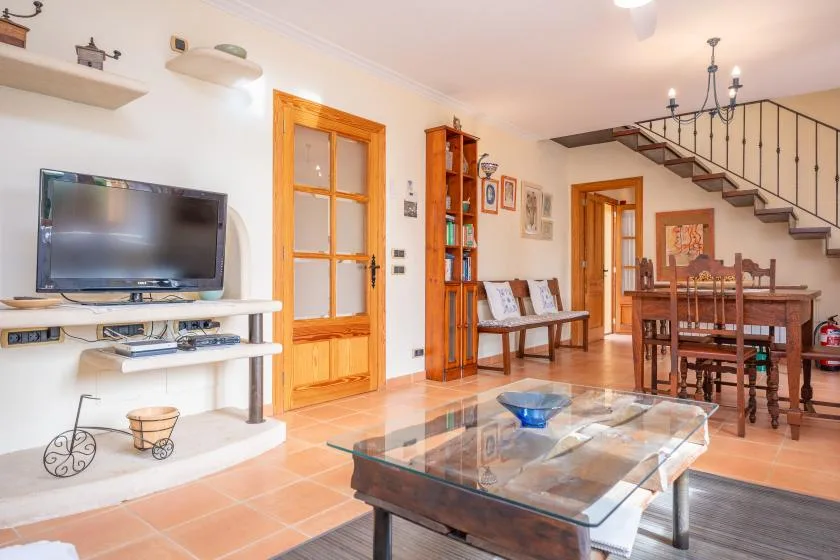 A living and dining area with a glass coffee table and wooden dining furniture.