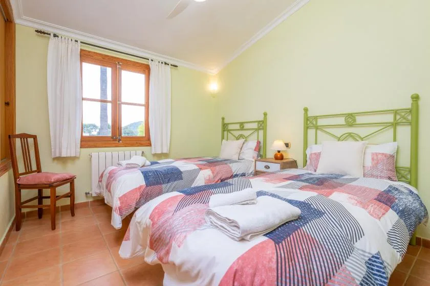 A bedroom with two beds dressed in colorful patterned bedding.