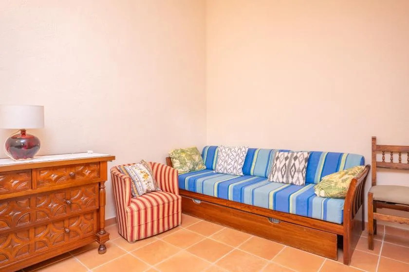 A living room with a blue-striped sofa and a small striped armchair.