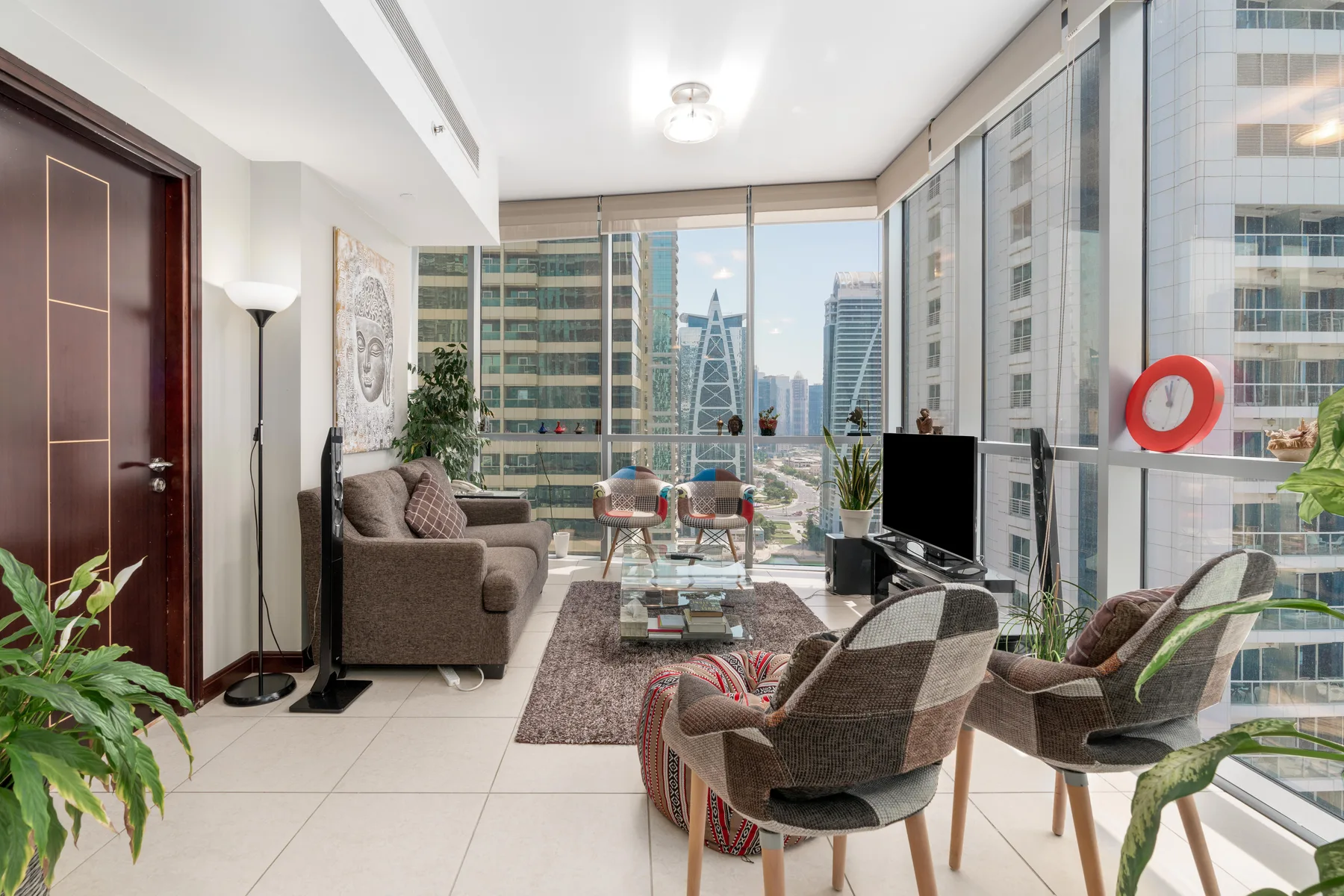 Una sala de estar con asientos y ventanales que dan a edificios de la ciudad.