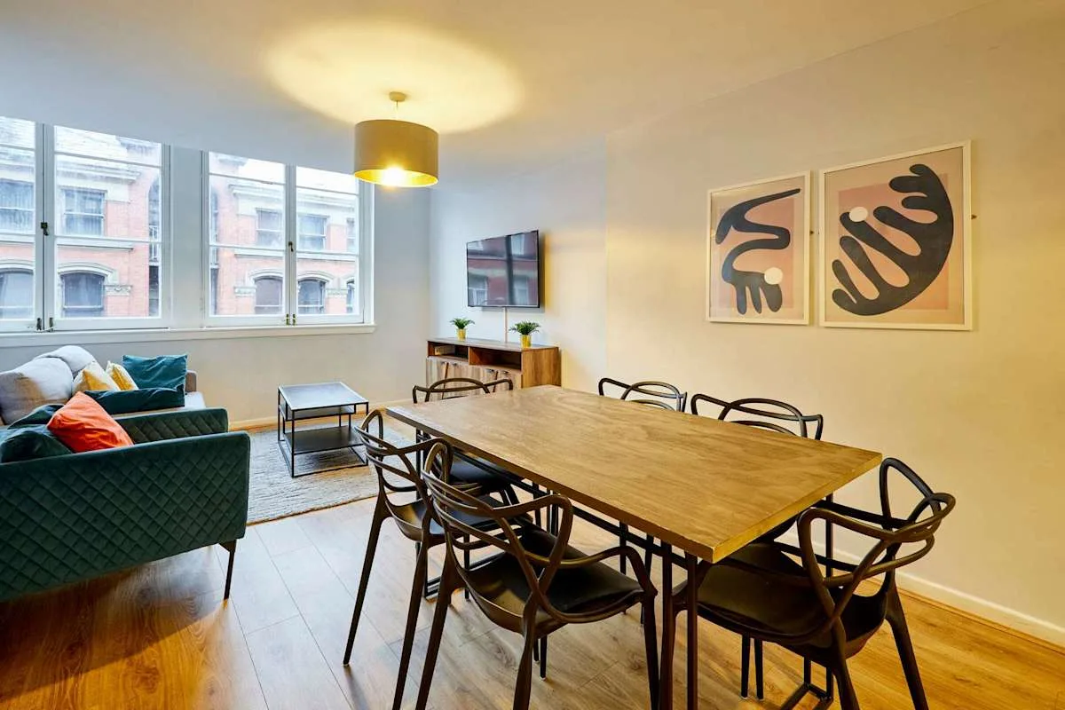 A dining area with a wooden table and seating beside a living area.