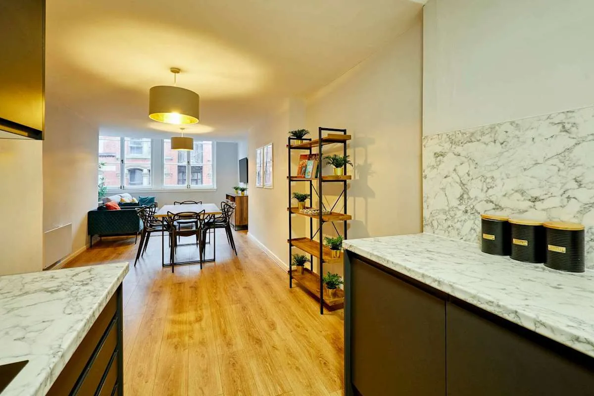 An open-plan kitchen and dining area with a living space by the windows.