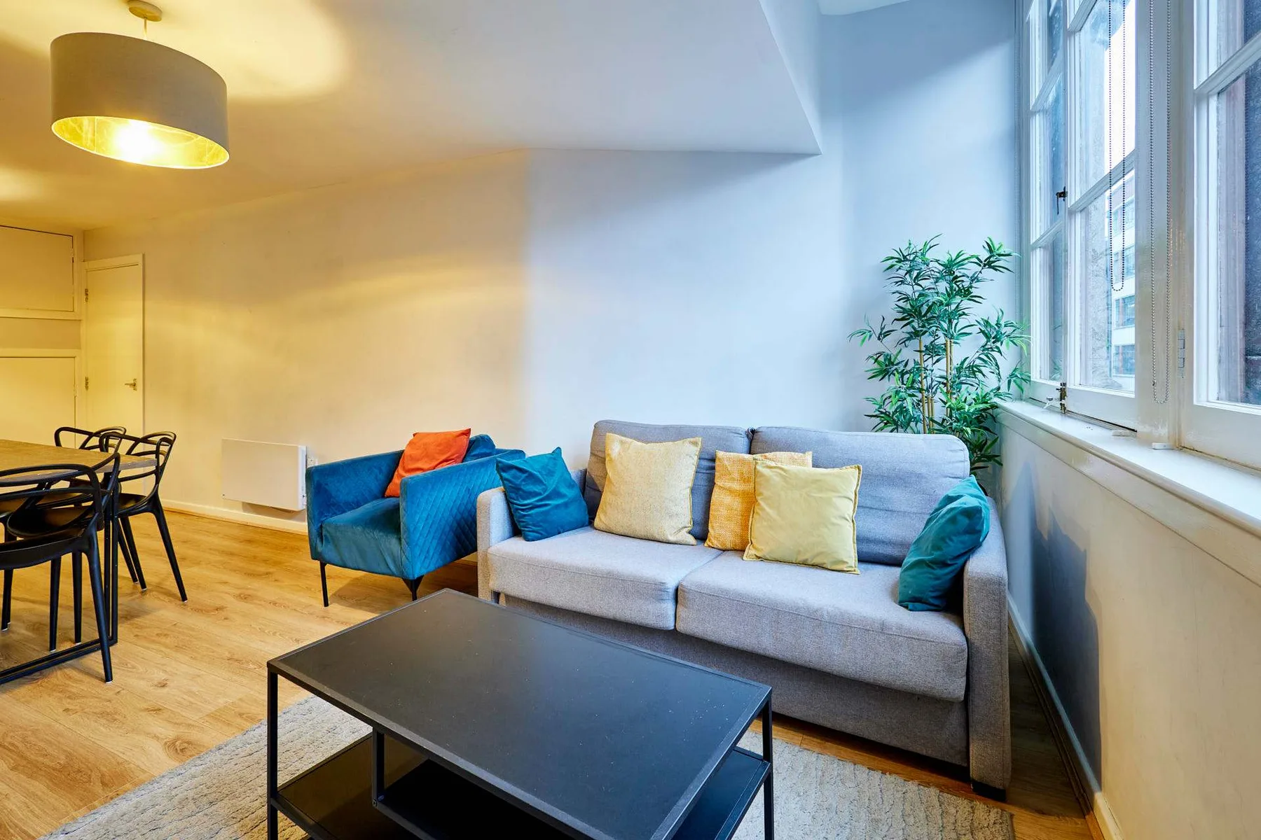 A living room with a gray sofa, blue armchair, and coffee table.