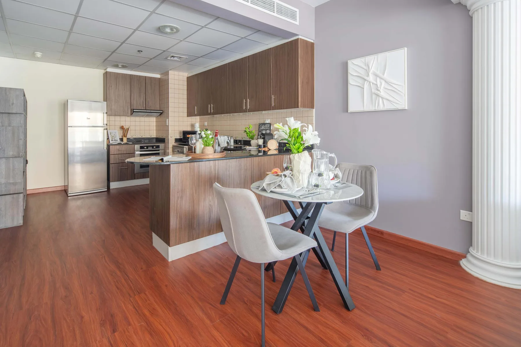 Una cocina moderna y zona de comedor con mesa y asientos.