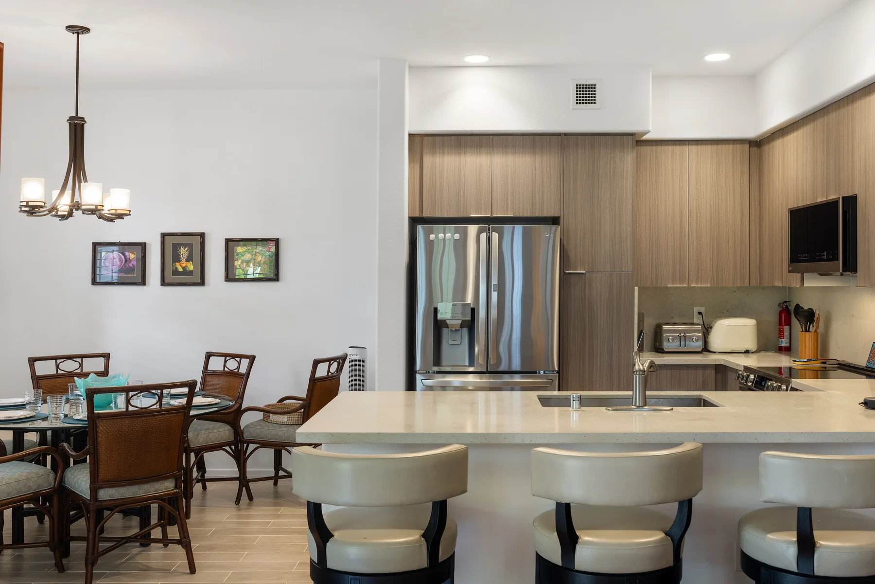 Cocina y comedor con una barra, asientos y una mesa de comedor.