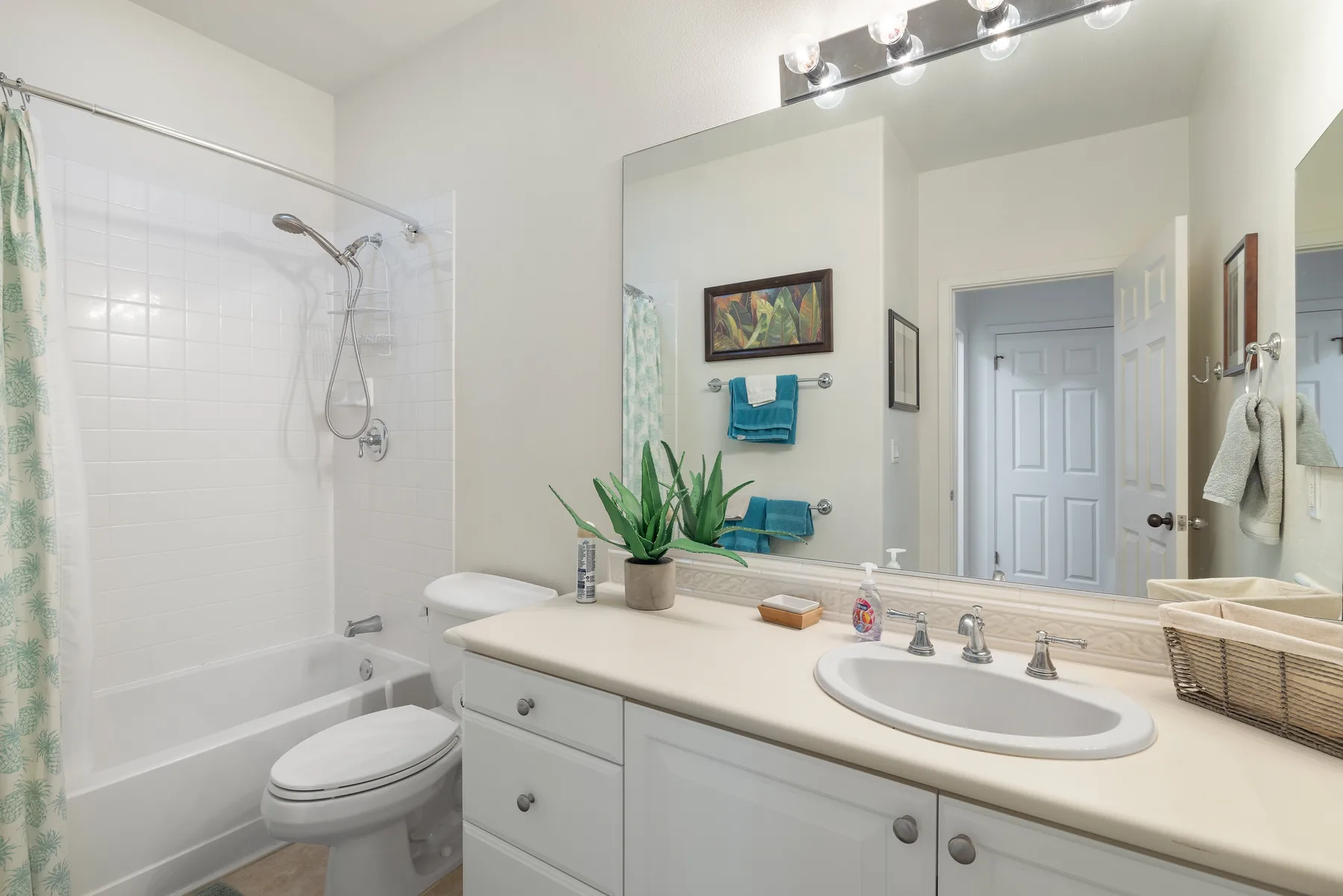 Un baño luminoso con bañera, ducha y tocador con lavabo.