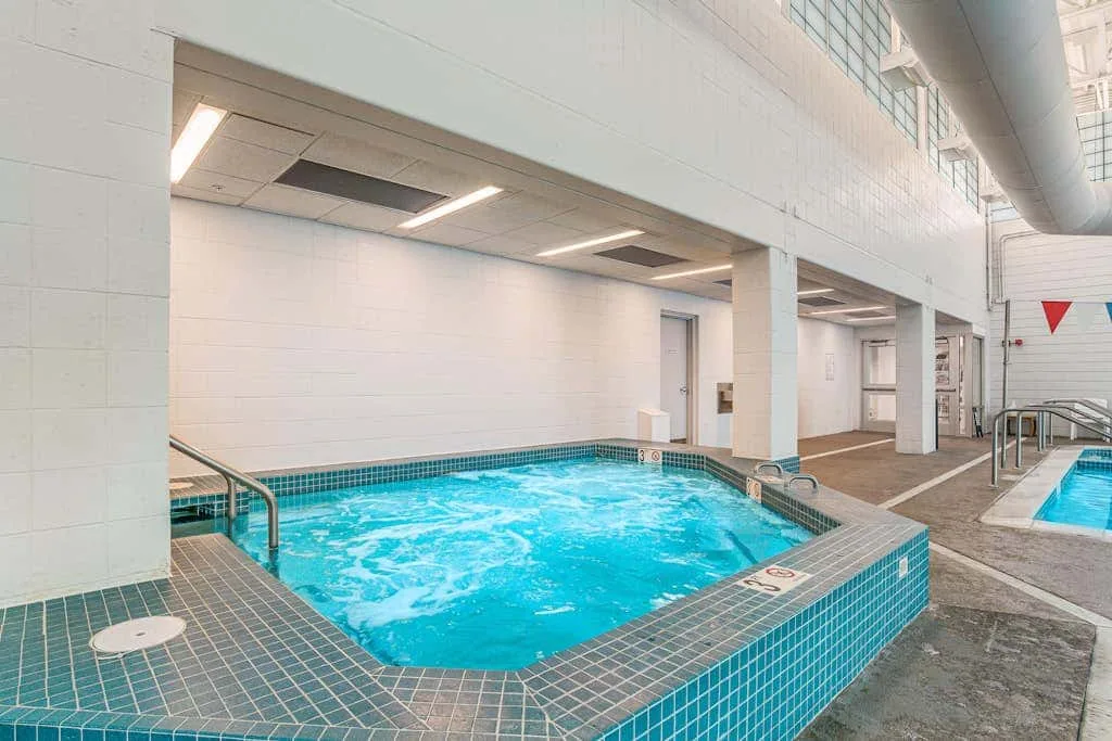 An indoor pool with turquoise water and tiled edges.